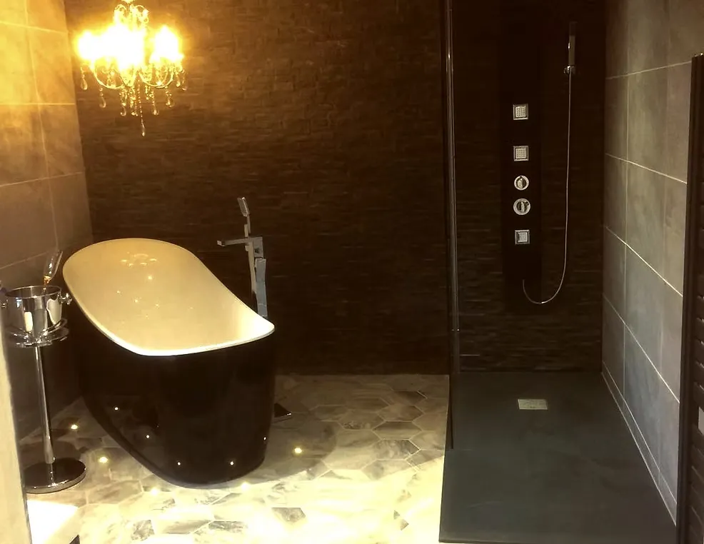 Warm-toned bathroom with a freestanding bath and feature wall