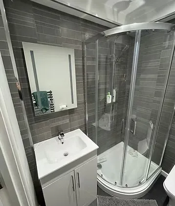 Graphite tile cladding with white bathroom furniture, fitted in Durham
