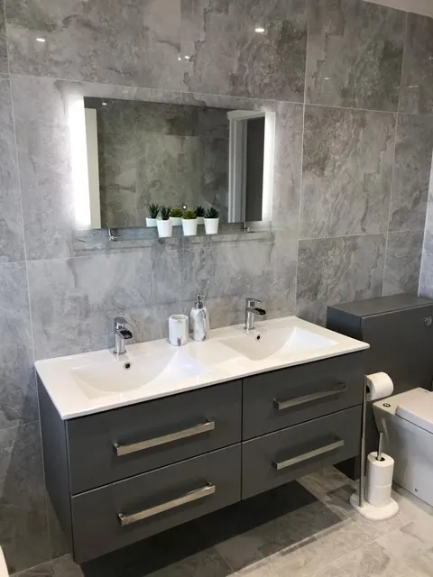 Fully tiled bathroom with modern vanity unit and large mirror, Durham