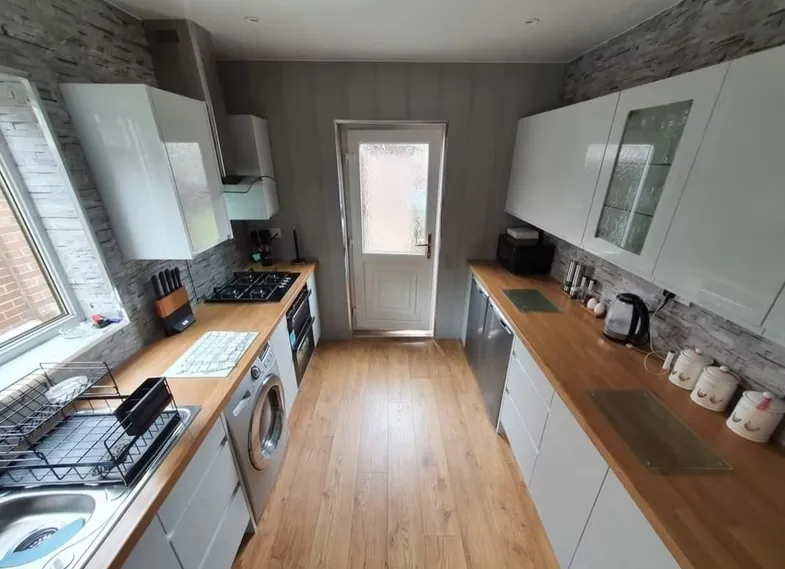 Fitted kitchen with wood-effect flooring and wall units